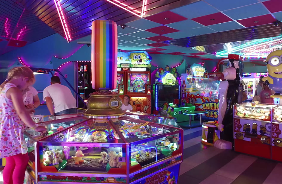 A group of people are playing games in a game room.